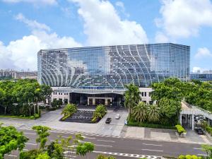 Hilton Guangzhou Baiyun - Canton Fair Free Shuttle Bus, 3km to Yuexiu District في قوانغتشو: مبنى كبير أمامه شارع