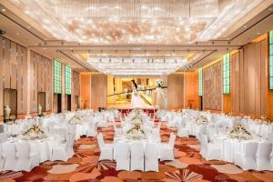 a banquet hall with white tables and white chairs at Hilton Guangzhou Baiyun - Canton Fair Free Shuttle Bus in Guangzhou