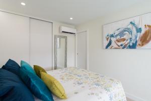 a bedroom with a bed with blue and yellow pillows at RENOVADO APARTAMENTO 1º LINEA DE MAR in San Agustin +26 photos