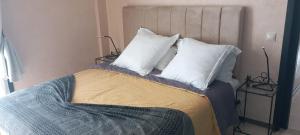 a bed with three pillows and two lamps at Couleur Magador in Essaouira