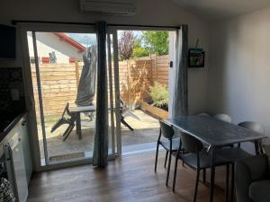 een eetkamer met een tafel en een glazen schuifdeur bij La landaise in Dax +8 foto's