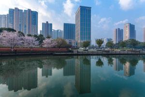 eine Skyline der Stadt mit einem Teich vor einer Stadt in der Unterkunft Hilton Changzhou in Changzhou