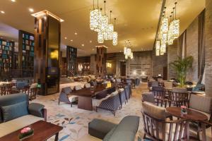 a restaurant with tables and chairs and chandeliers at Hilton Changzhou in Changzhou