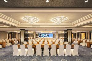 um quarto grande com uma grande mesa e cadeiras em Hilton Foshan em Foshan