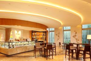 um restaurante com mesas e cadeiras e um bar em DoubleTree by Hilton Hangzhou East em Hangzhou