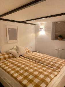 - une chambre avec un lit et une couverture en damier dans l'établissement Scheunentraum Brenig, à Bornheim