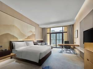 ein Hotelzimmer mit einem Bett und einem Schreibtisch in der Unterkunft Doubletree By Hilton Quzhou in Quzhou