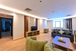 a living room with a couch and a table at Saray Musheireb Hotel Suites and Apartment in Doha