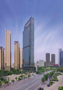 a tall building in the middle of a city at Hilton Shenyang in Shenyang