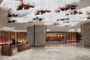 een weergave van een lobby met een grote kroonluchter bij Hilton Shenyang in Shenyang