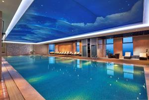 蕪湖的住宿－蕪湖世茂希爾頓逸林酒店，一座大型游泳池,天花板上画着画