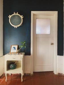 a hallway with a white door and a mirror on a wall at Palacio de la luna, casa única frente al mar in Cabo Polonio