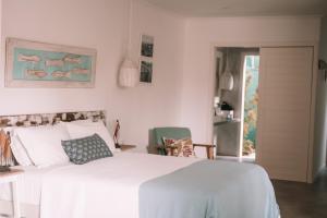 Un dormitorio con una gran cama blanca y una ventana en Cactus Lodge Pipa, en Pipa