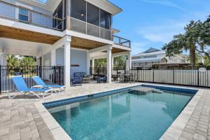 a swimming pool with two chairs and a house at Fruitcakes in St. George Island