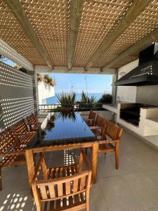 eine Außenterrasse mit einem Tisch und Stühlen in der Unterkunft Departamento 1D1B Condominio Altos de Huayquique in Iquique