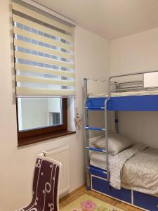 a bedroom with bunk beds with a window and a guitar at Apartment Centar Sarajevo in Sarajevo
