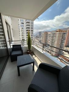 un balcón con 2 sofás y una mesa en un edificio en Departamento 1D1B Condominio Altos de Huayquique, en Iquique