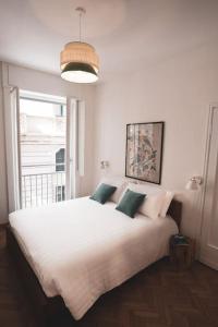 ein Schlafzimmer mit einem großen weißen Bett mit grünen Kissen in der Unterkunft Insidewonderfulcomo in Como