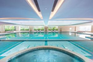 a large indoor swimming pool with a large ceiling at Hilton Zhongshan Downtown in Zhongshan