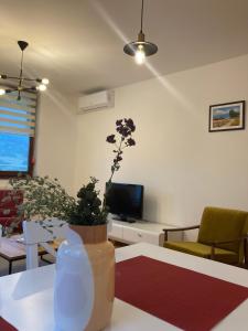 a living room with a vase with flowers on a table at Apartment Centar Sarajevo in Sarajevo