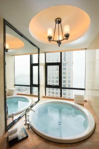 a large bathroom with a large tub with windows at Hilton Zhongshan Downtown in Zhongshan