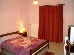 1 dormitorio con cama y cortina roja en Pavlou Rooms, en Ioannina