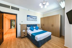 a bedroom with a large bed and a television at Saray Musheireb Hotel Suites and Apartment in Doha