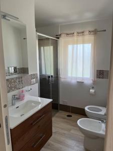 ein Bad mit einem Waschbecken, einem WC und einer Dusche in der Unterkunft La Villa Dei Sogni in Formia