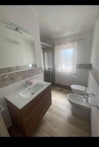 ein Badezimmer mit einem Waschbecken, einem WC und einem Spiegel in der Unterkunft La Villa Dei Sogni in Formia