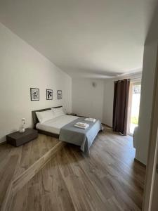 ein weißes Schlafzimmer mit einem Bett und Holzboden in der Unterkunft La Villa Dei Sogni in Formia