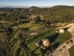 an aerial view of a golf course with mountains in the background at Kairos Glamping - Rancho Queimado - SC in Rancho Queimado