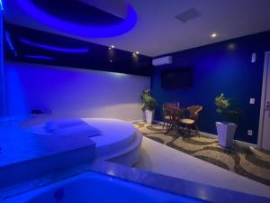 um quarto azul com um WC e uma mesa em Passione Criciúma - Adult Only em Criciúma