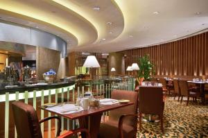 restauracja ze stołami i krzesłami oraz bar w obiekcie Hilton Chongqing w mieście Chongqing
