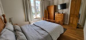 a bedroom with a bed and a dresser and a television at Musselburgh / Edinburgh near QM Uni (30) in Fisherrow