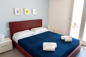 マリーナ・ディ・ラグーザにあるEdilia Vacanzeのベッドルーム1室(ベッド1台、タオル2枚付)