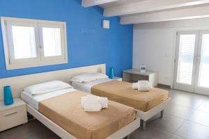 マリーナ・ディ・ラグーザにあるEdilia Vacanzeの青い壁と窓が特徴の客室で、ベッド2台が備わります。
