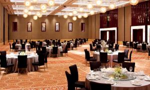 un salón de banquetes con mesas, sillas y lámparas de araña en DoubleTree By Hilton Wuxi en Wuxi