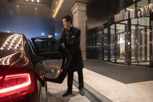 un hombre entrando en un coche en una tienda en DoubleTree by Hilton Hotel Shiyan en Shiyan