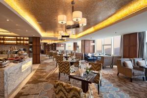 a restaurant with tables and chairs and a bar at DoubleTree by Hilton Hotel Putian in Putian
