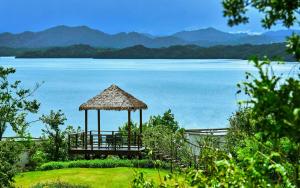 a gazebo next to a large body of water at Lushan West Sea Resort, Curio Collection by Hilton in Jiujiang