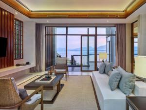 een woonkamer met een witte bank en een tafel bij Lushan West Sea Resort, Curio Collection by Hilton in Jiujiang