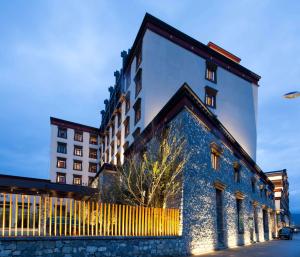 a tall building with a fence in front of it at Hilton Garden Inn Shangri-La in Shangri-La