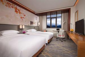 Habitación de hotel con 2 camas y TV en Hilton Garden Inn Shangri-La en Shangri-La