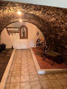 Habitación con mesa y pared de piedra. en VILLA Sebe 