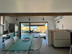 een keuken en eetkamer met een glazen tafel en stoelen bij OUSTAL CAVAL MARIN A in Valras-Plage