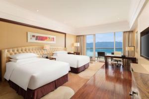 a hotel room with two beds and a television at Hilton Hangzhou Qiandao Lake Resort in Chun'an