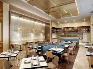 un comedor con mesas y sillas y un restaurante en Hilton Garden Inn Heze, en Heze