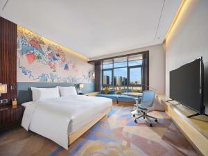 a hotel room with a bed and a tv at Hilton Garden Inn Heze in Heze