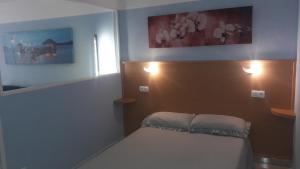 a bedroom with a bed and two pictures on the wall at Apartamentos TSS Alboran in Salou