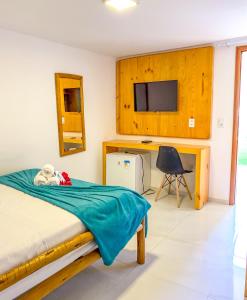 Dormitorio con cama, escritorio y TV en POUSADA OBAH VILLAGE, en Prea